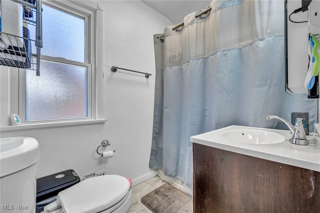 Bathroom featuring a shower with curtain and vanity