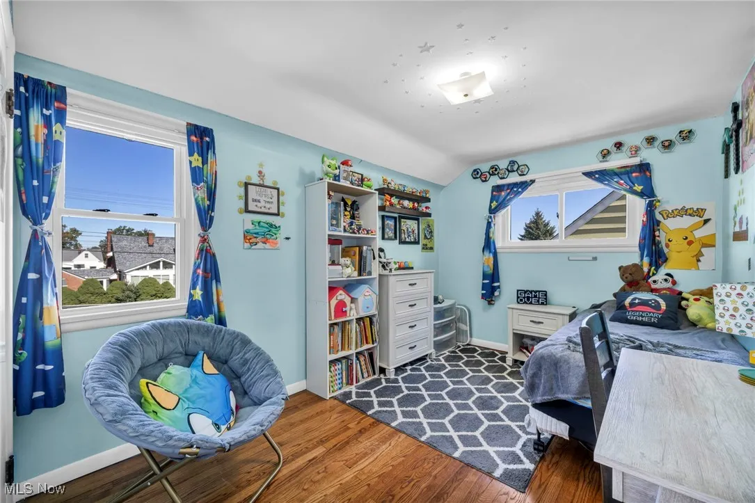 Bedroom featuring dark wood-style flooring and vaulted ceiling