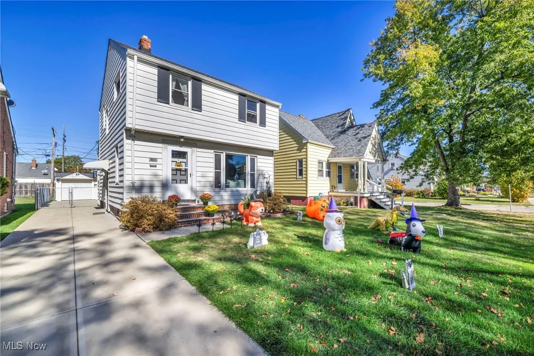 Colonial home with a front lawn, a chimney, and entry steps