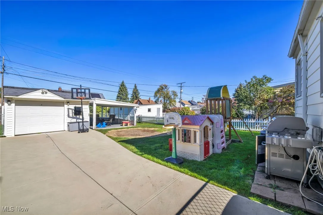 View of yard featuring a playground, a patio, an outbuilding, and a detached garage