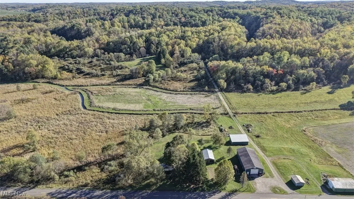 Aerial overview of property's location with a heavily wooded area and rural landscape