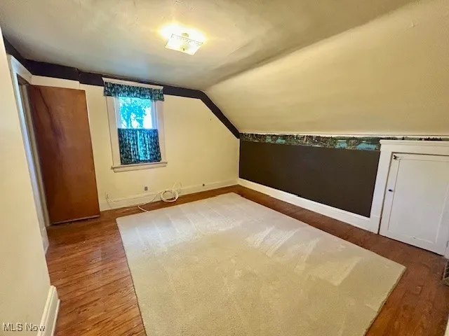 Additional living space featuring vaulted ceiling and wood finished floors