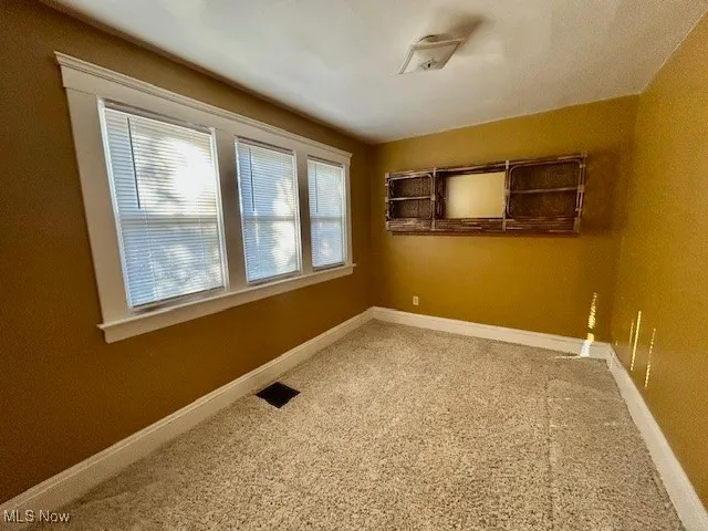 Empty room with carpet floors and baseboards
