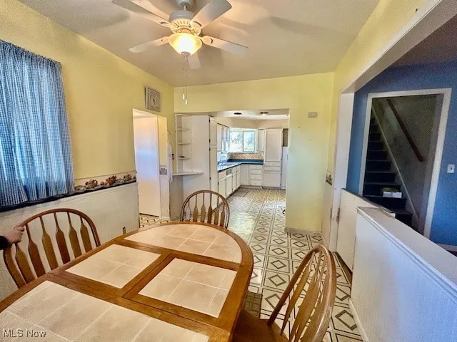 Dining area featuring a ceiling fan and light floors