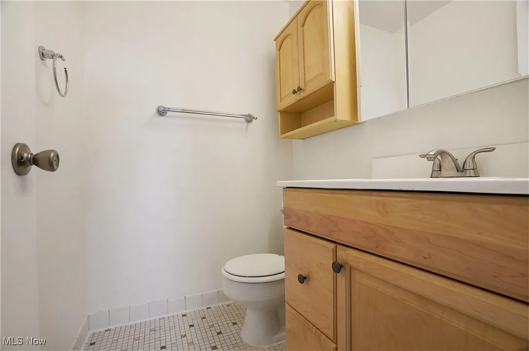 Half bath featuring vanity and light tile patterned floors in primary bedroom