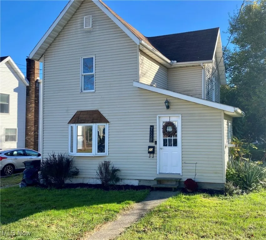 Traditional home with a front yard and entry steps