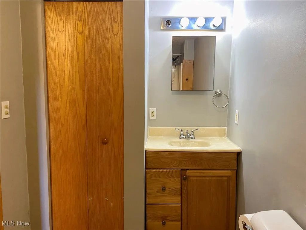 Half bathroom featuring vanity and toilet