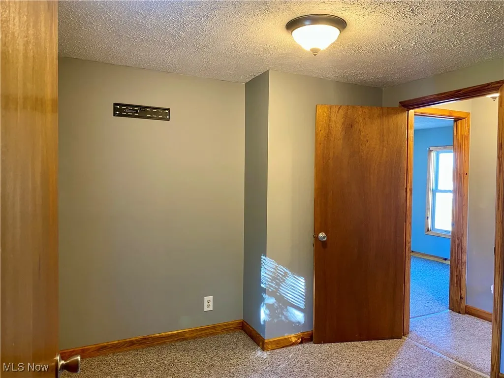 Spare room with a textured ceiling and carpet