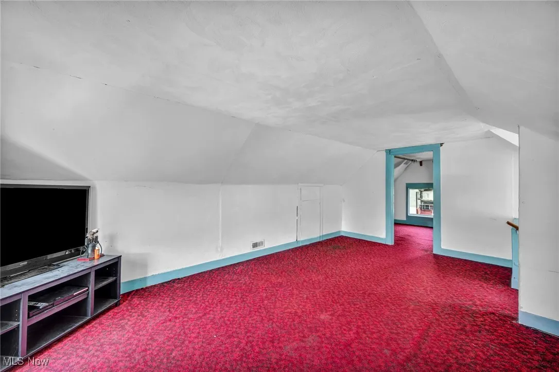 Bonus room with carpet flooring and lofted ceiling