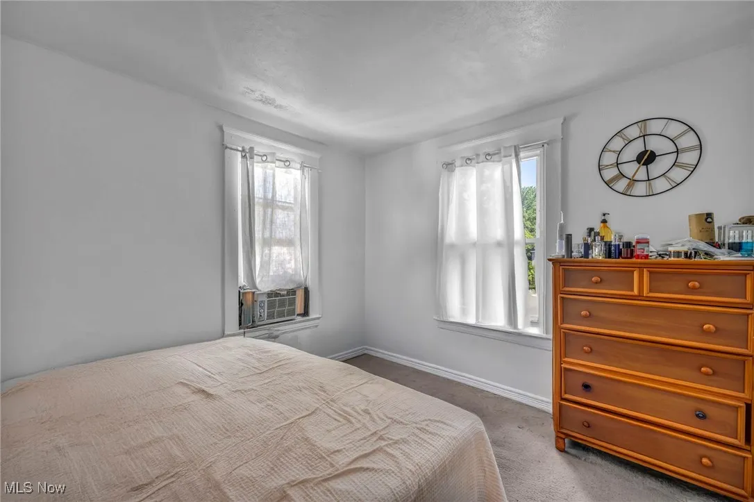 Bedroom with carpet, multiple windows, and cooling unit