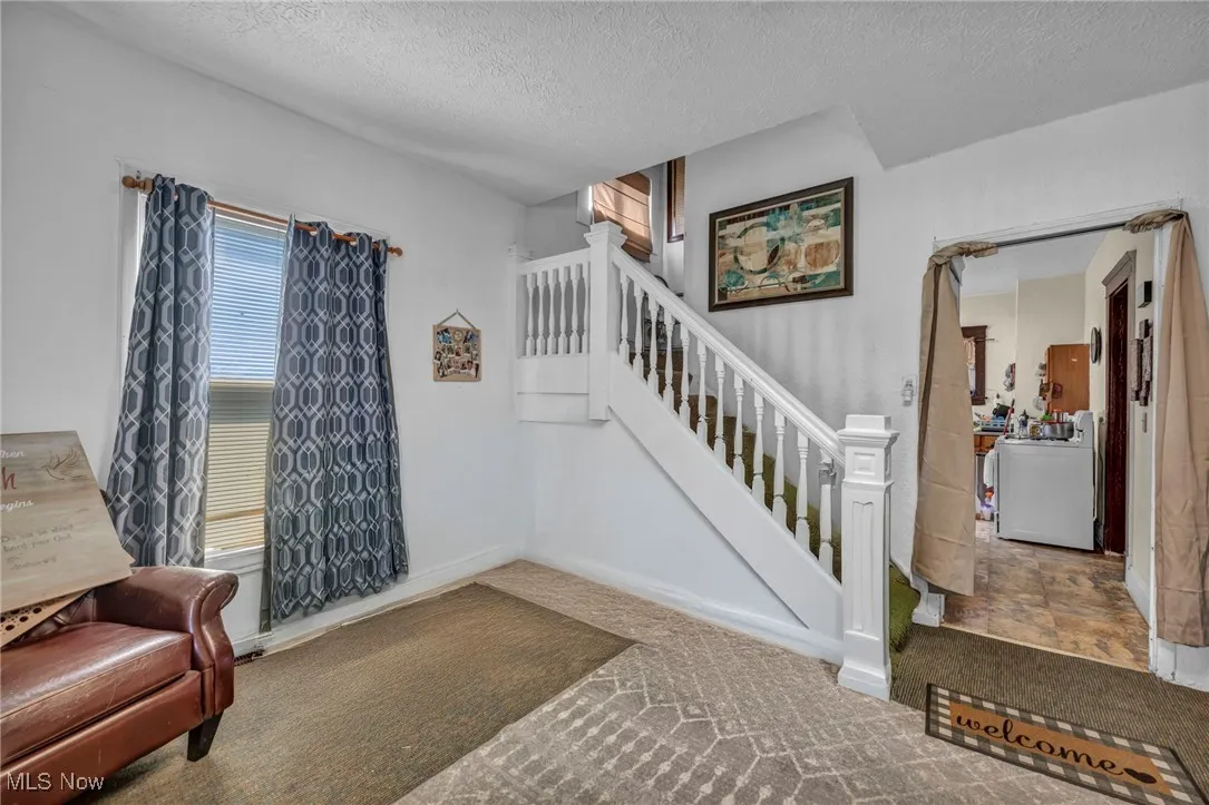 Stairway with a textured ceiling and carpet