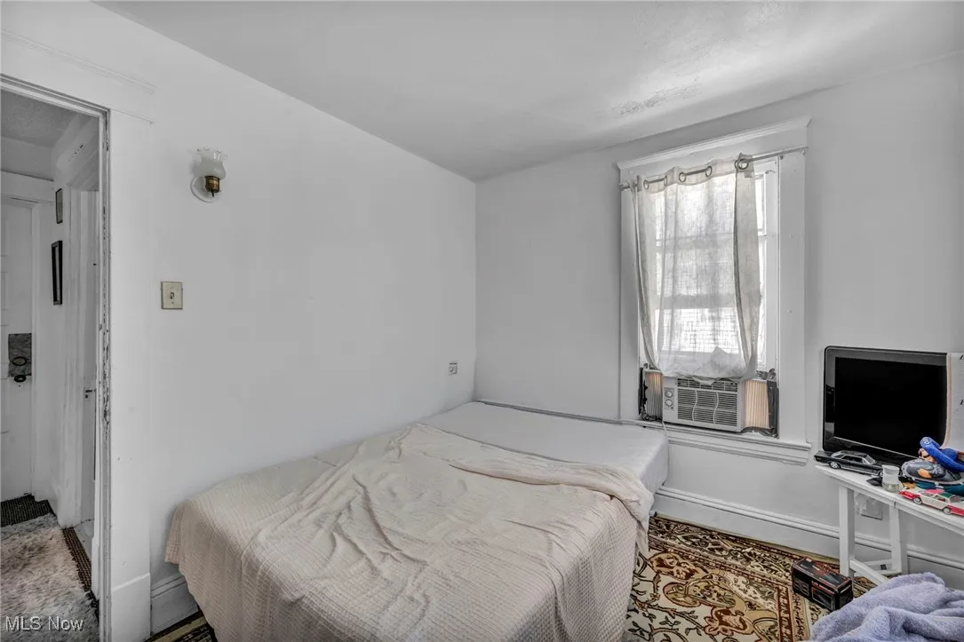 Bedroom with baseboards and cooling unit