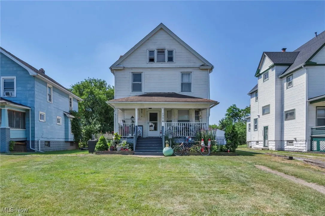 Traditional style home with covered porch and a front yard