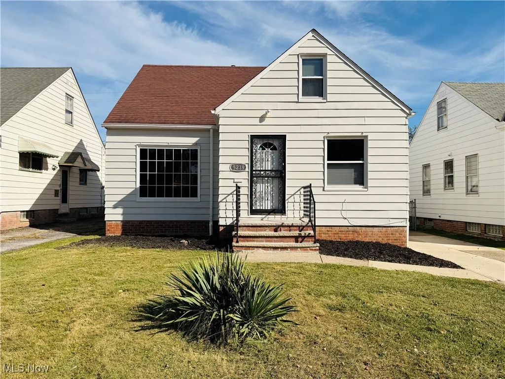 View of front of property with a front lawn and roof with shingles