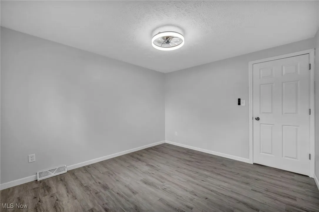 Unfurnished room featuring wood finished floors and a textured ceiling
