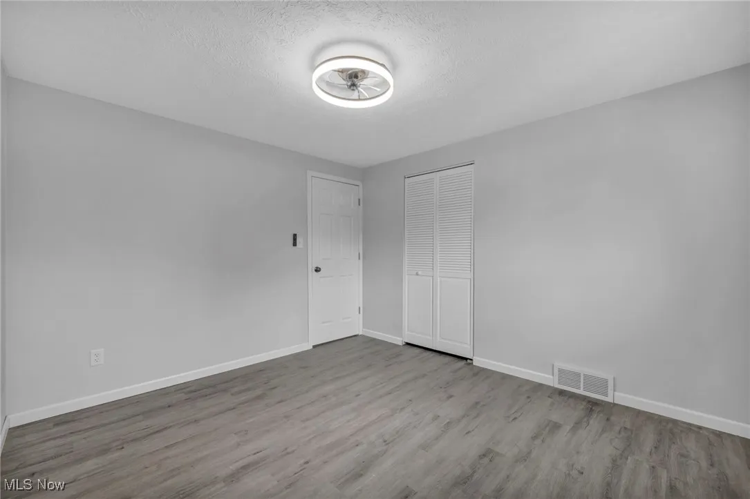 Unfurnished bedroom with wood finished floors, a textured ceiling, and a closet