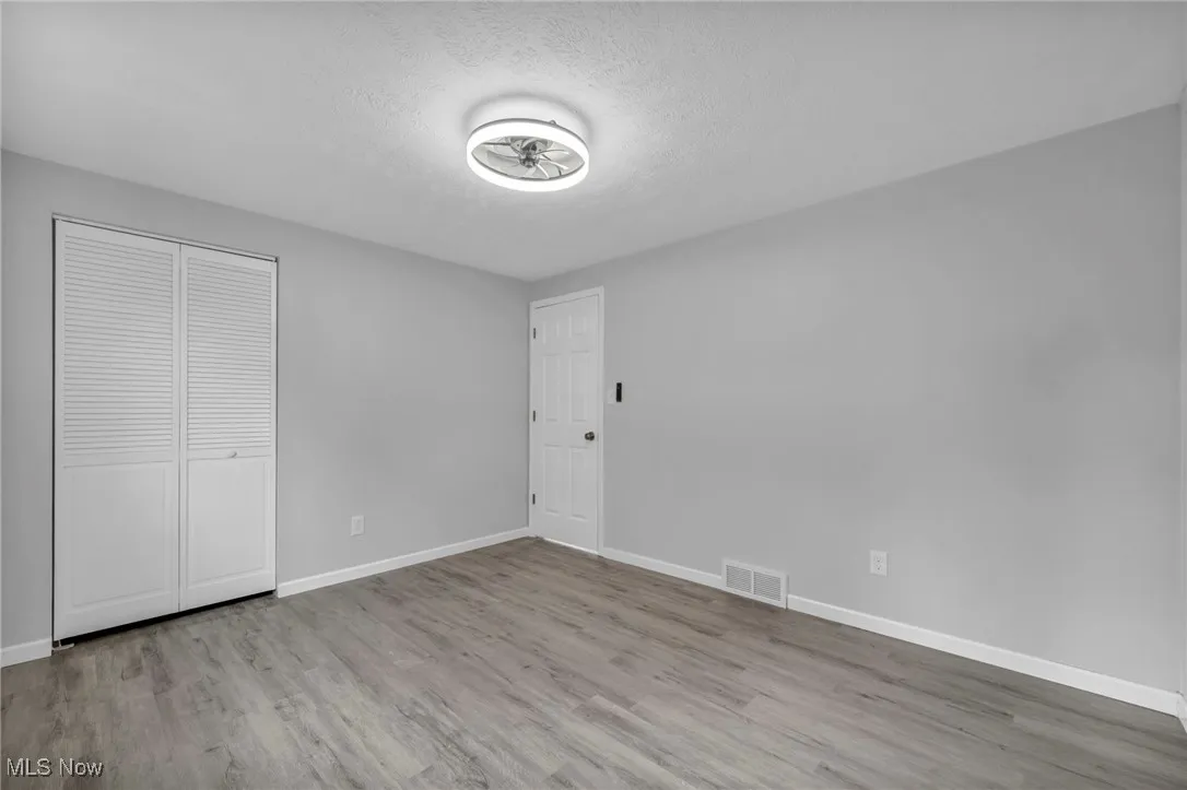 Unfurnished bedroom featuring light wood-style floors, a textured ceiling, and a closet