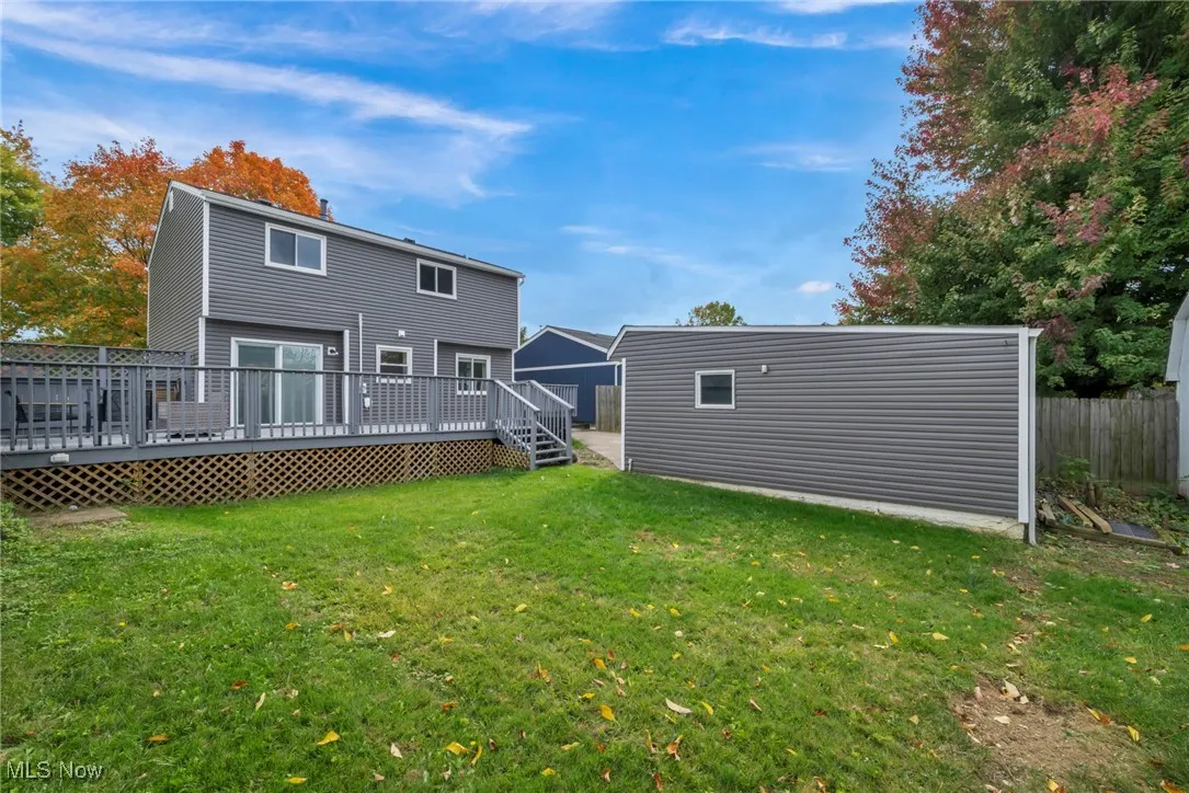 Back of house with an outdoor structure and a wooden deck