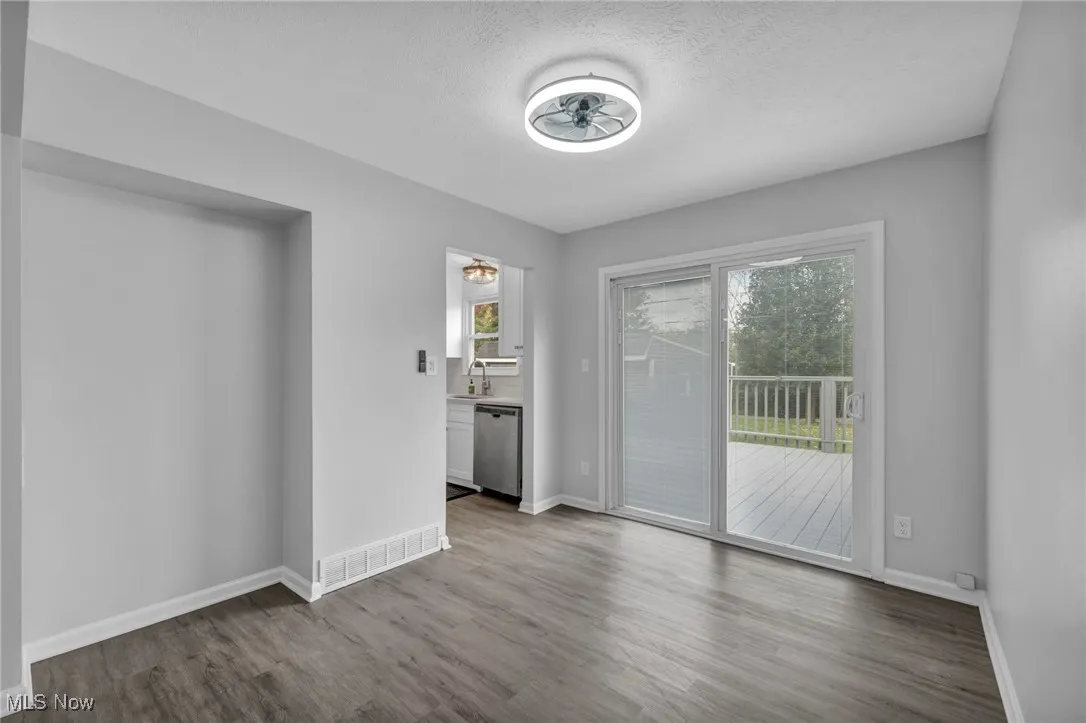 Unfurnished room with plenty of natural light, wood finished floors, and a textured ceiling