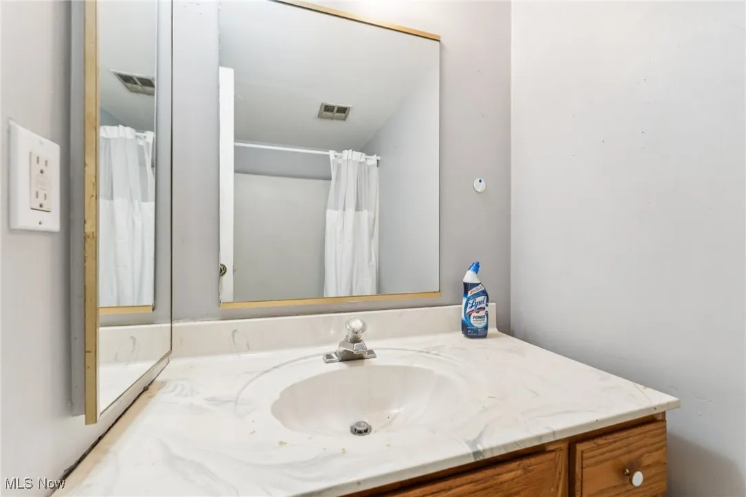 Full bath with vanity and curtained shower