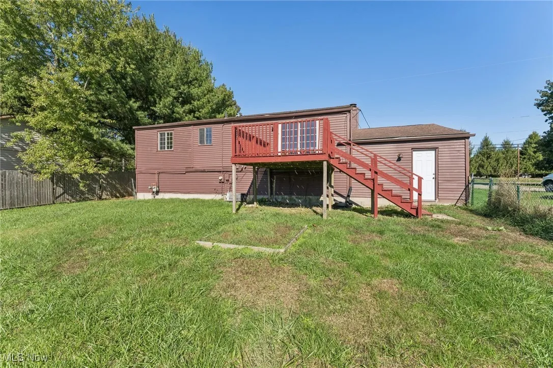 Rear view of house featuring stairs and a deck