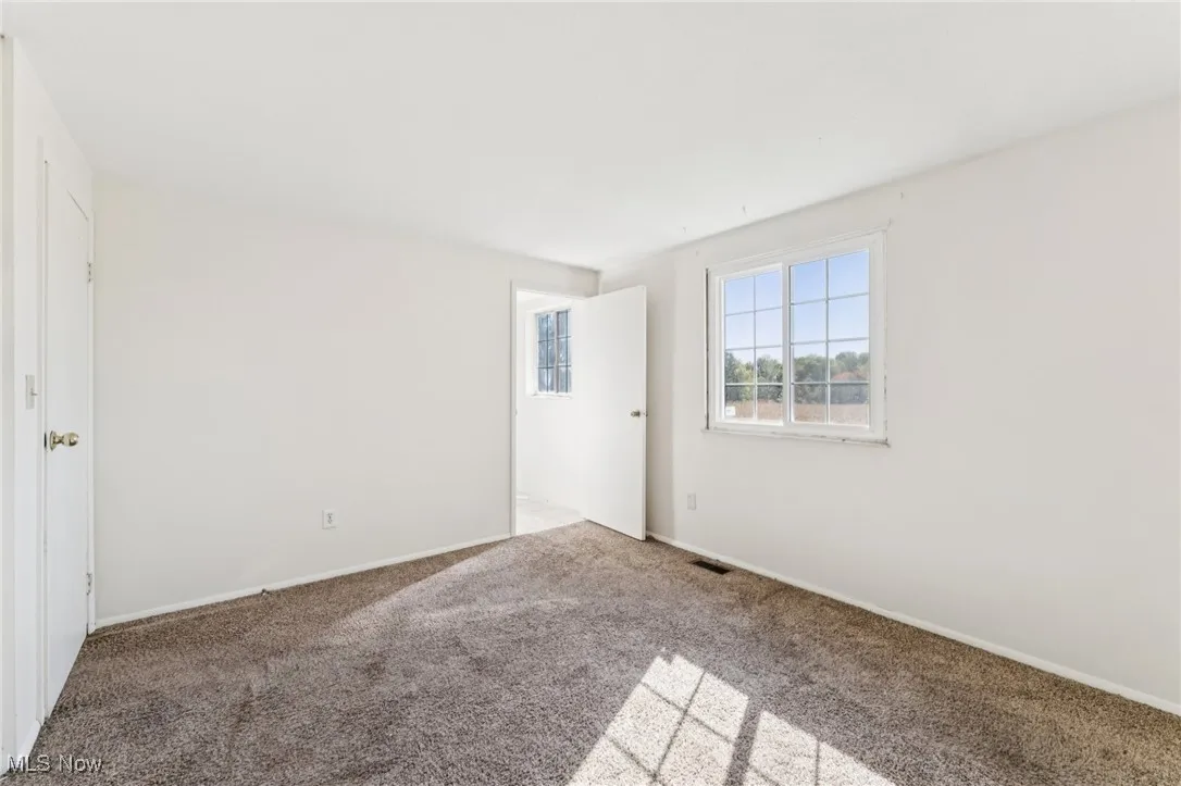 Spare room featuring carpet floors and baseboards