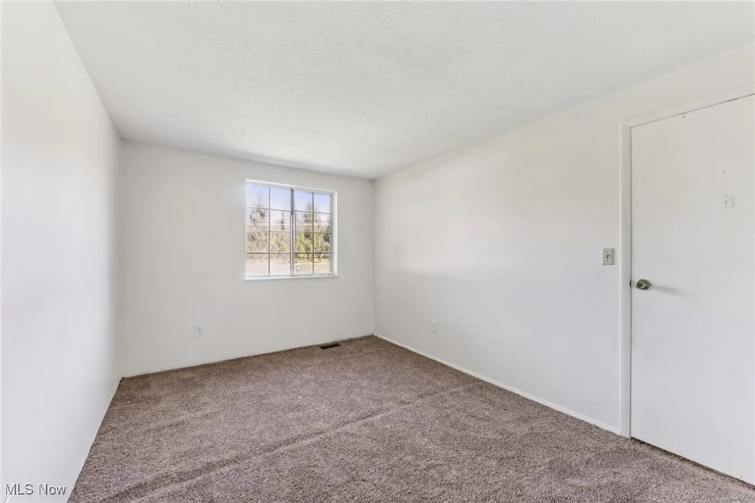 Carpeted spare room with a textured ceiling