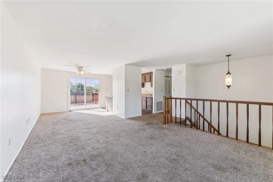 Carpeted empty room with ceiling fan