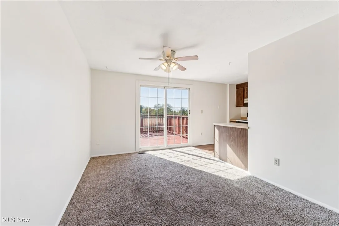 Unfurnished living room with light carpet and a ceiling fan