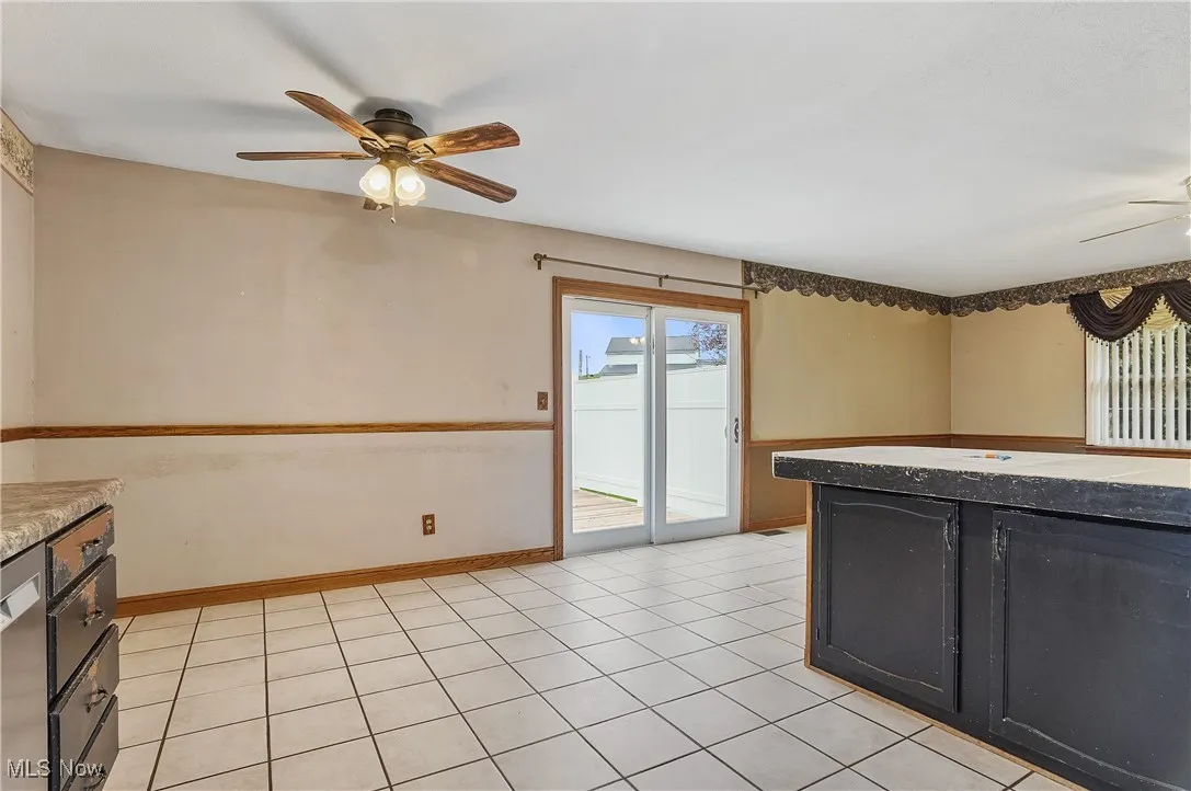 Kitchen with a ceiling fan, dark cabinetry, and light tile patterned floors
