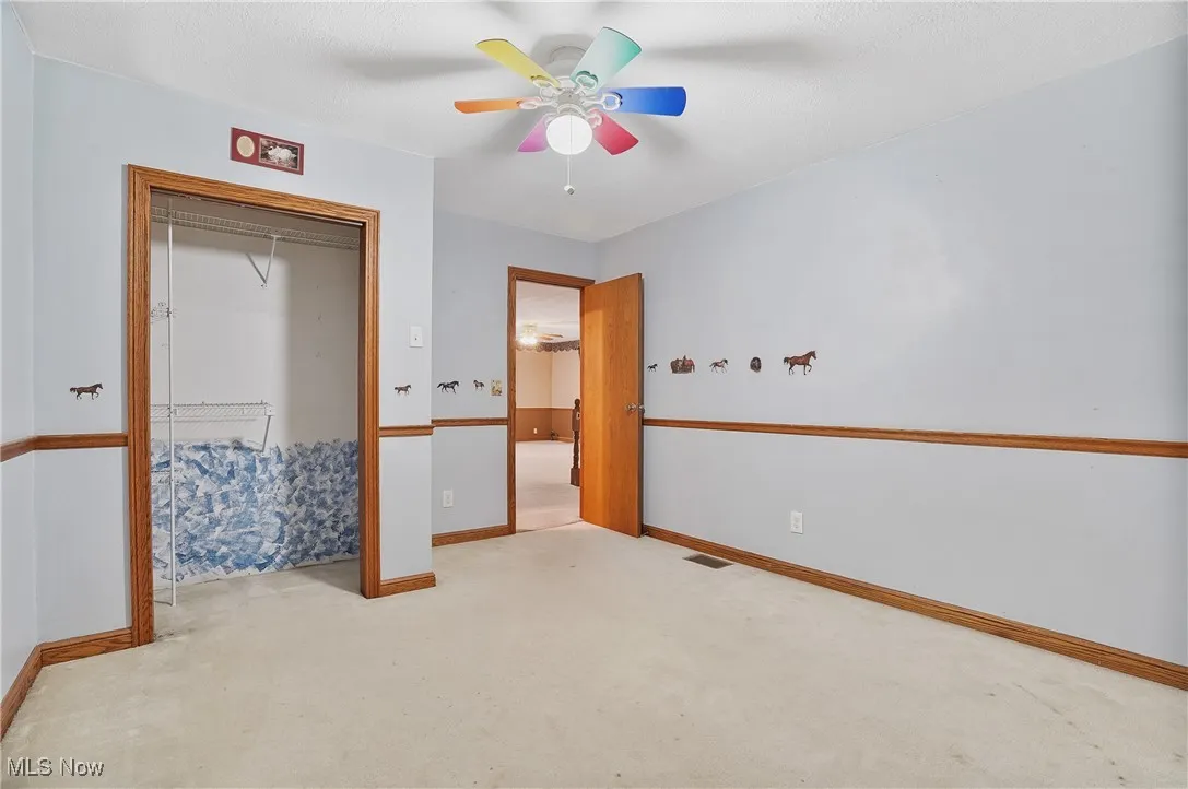 Unfurnished bedroom featuring carpet floors, a closet, and ceiling fan