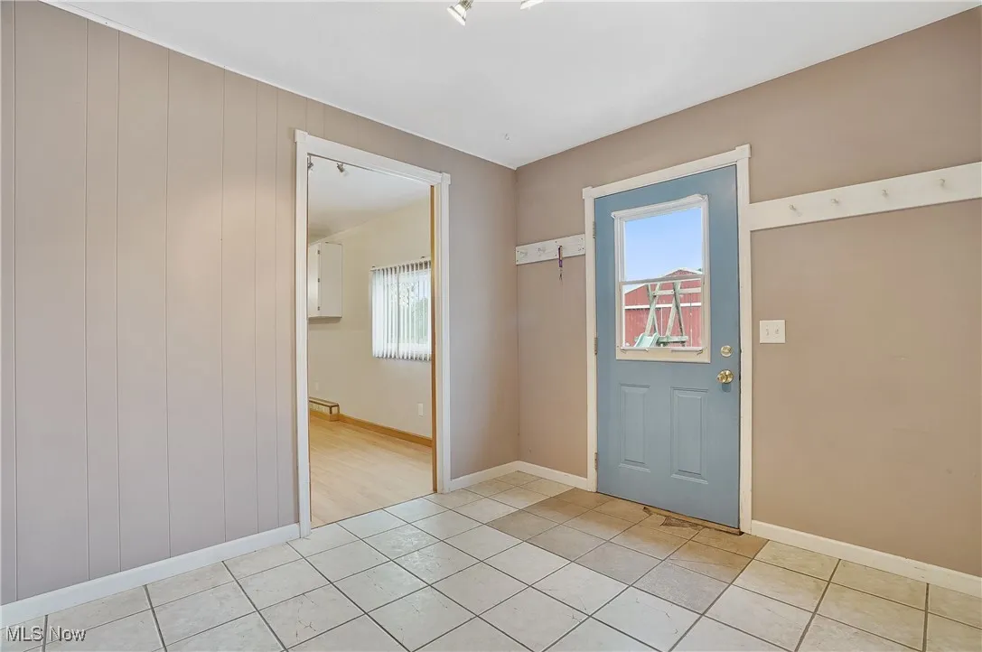 Foyer entrance featuring light tile patterned floors and baseboards