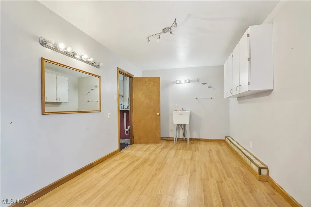 Laundry room with light wood-type flooring and baseboards