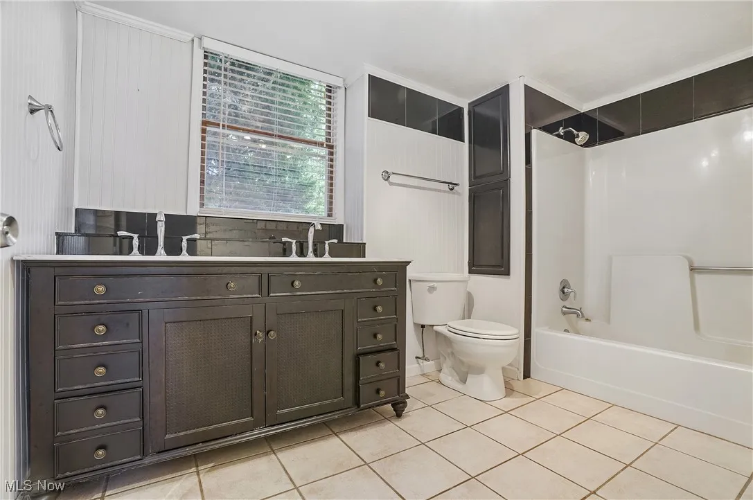 Full bathroom featuring shower / bathtub combination, light tile patterned floors, and vanity