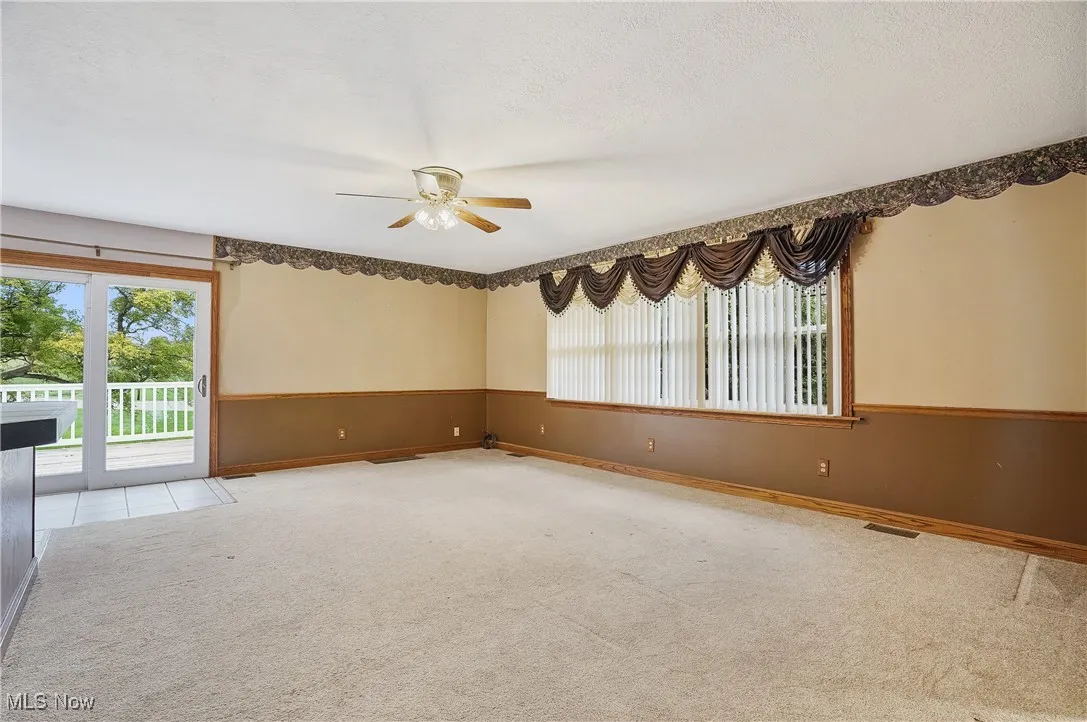 Spare room with carpet floors, a ceiling fan, and a textured ceiling