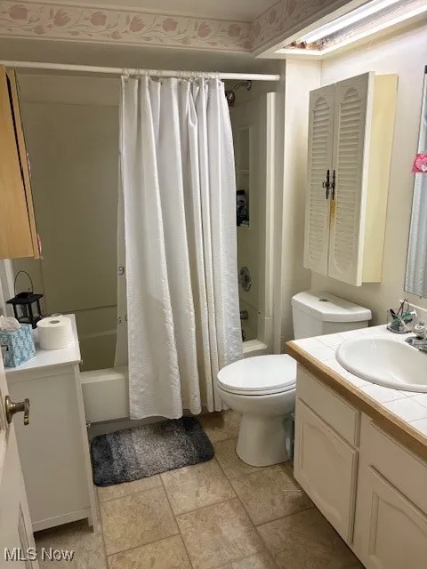 Full bathroom with vanity and shower / bath combo with shower curtain