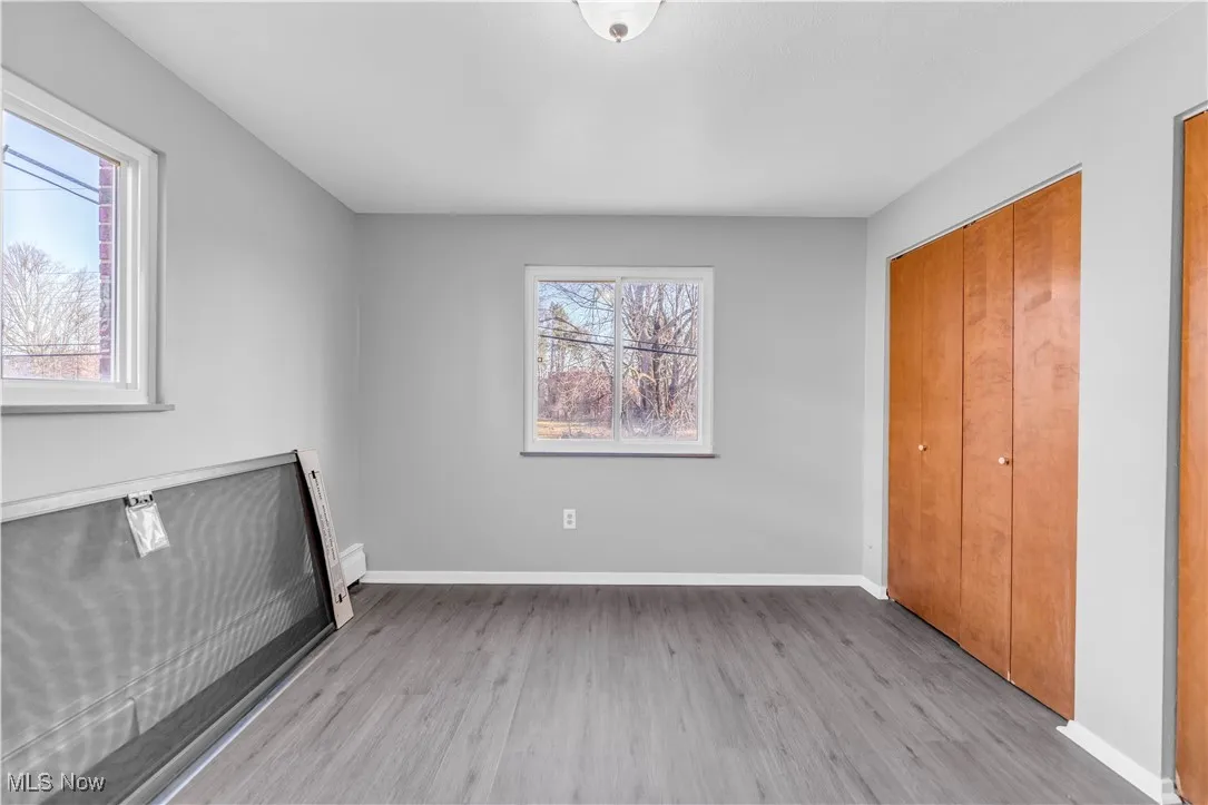 Unfurnished bedroom featuring light wood-type flooring and two closets
