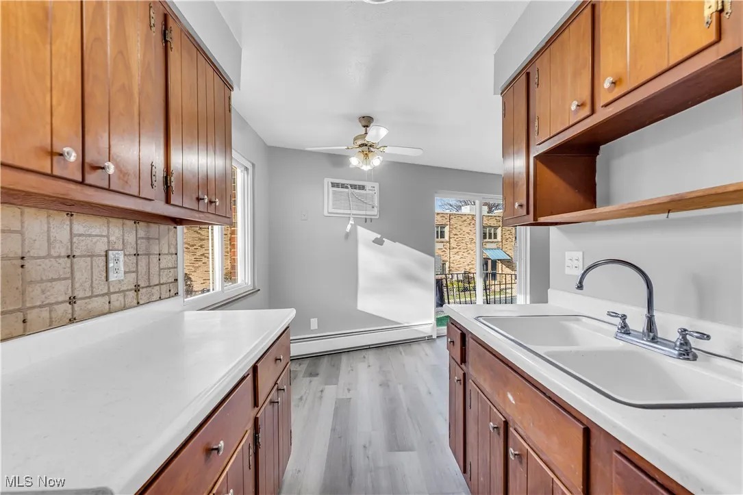 Kitchen featuring brown cabinets, light wood-style flooring, and open shelves
