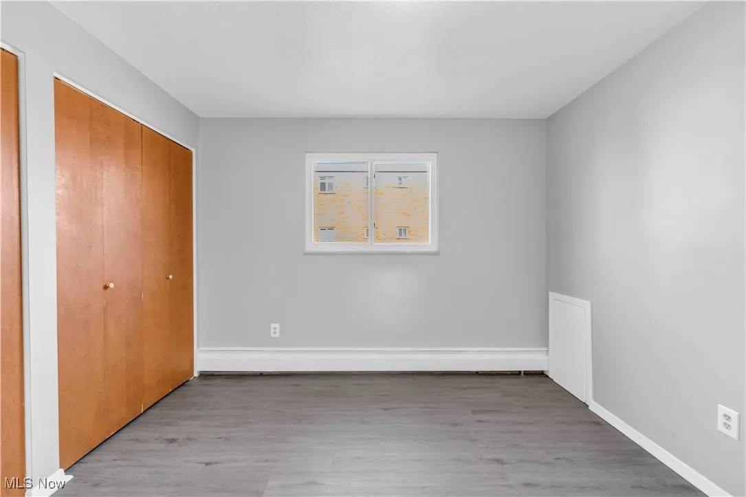 Unfurnished bedroom with light wood-style floors and multiple closets