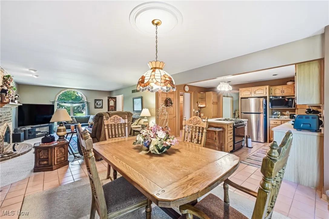 Dining space with light tile patterned floors and a fireplace