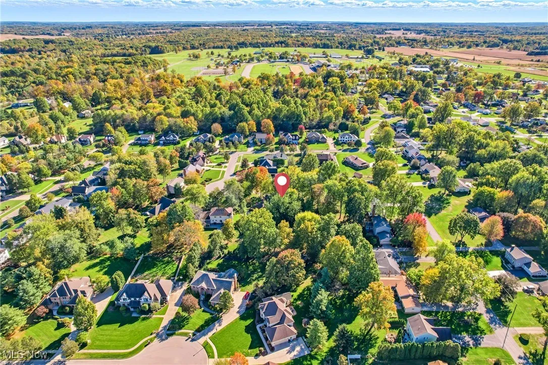 Aerial view of property and surrounding area featuring nearby suburban area