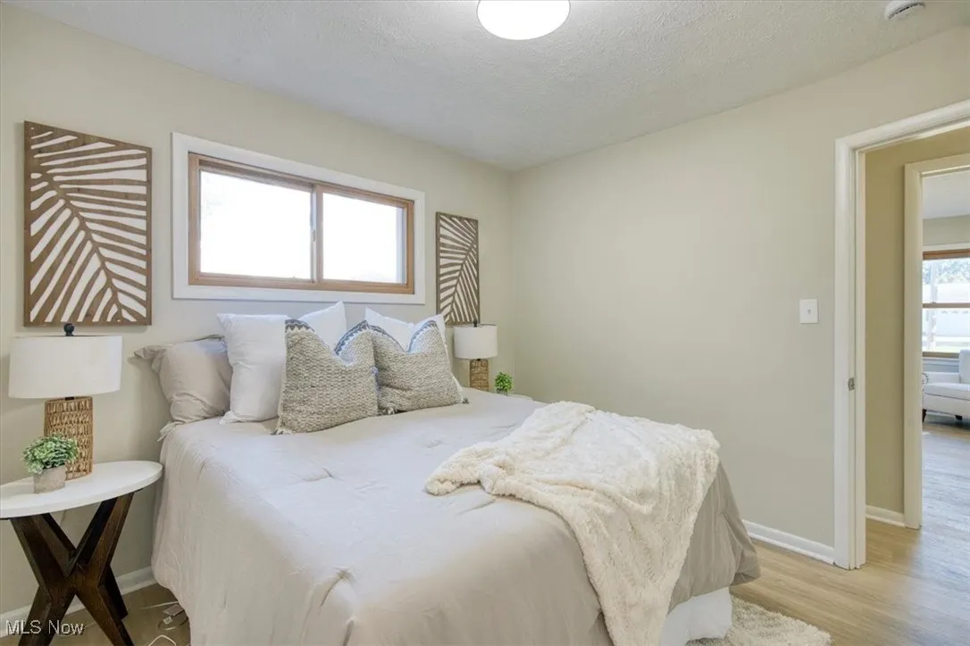 Bedroom featuring a textured ceiling and wood finished floors