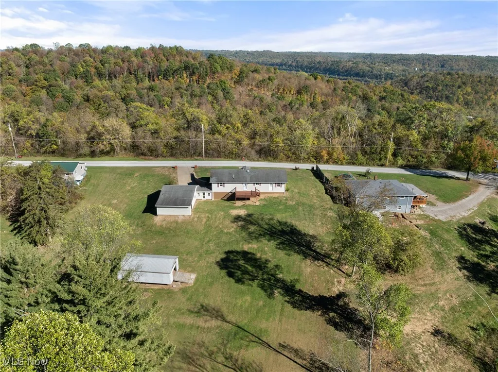 Aerial view of property's location with a heavily wooded area