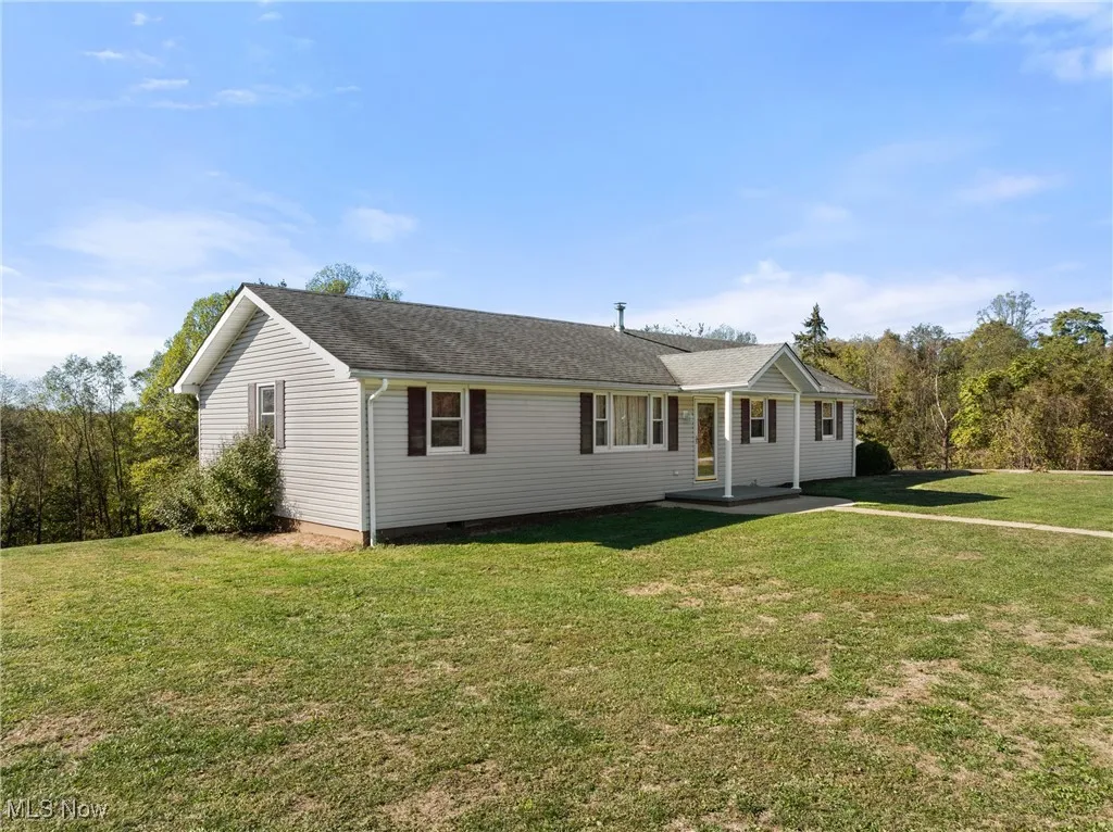 Single story home featuring a front yard and a shingled roof