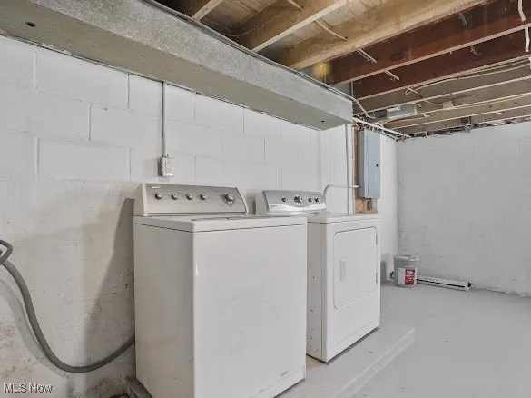 Laundry room with concrete floors, washing machine and clothes dryer, and electric panel