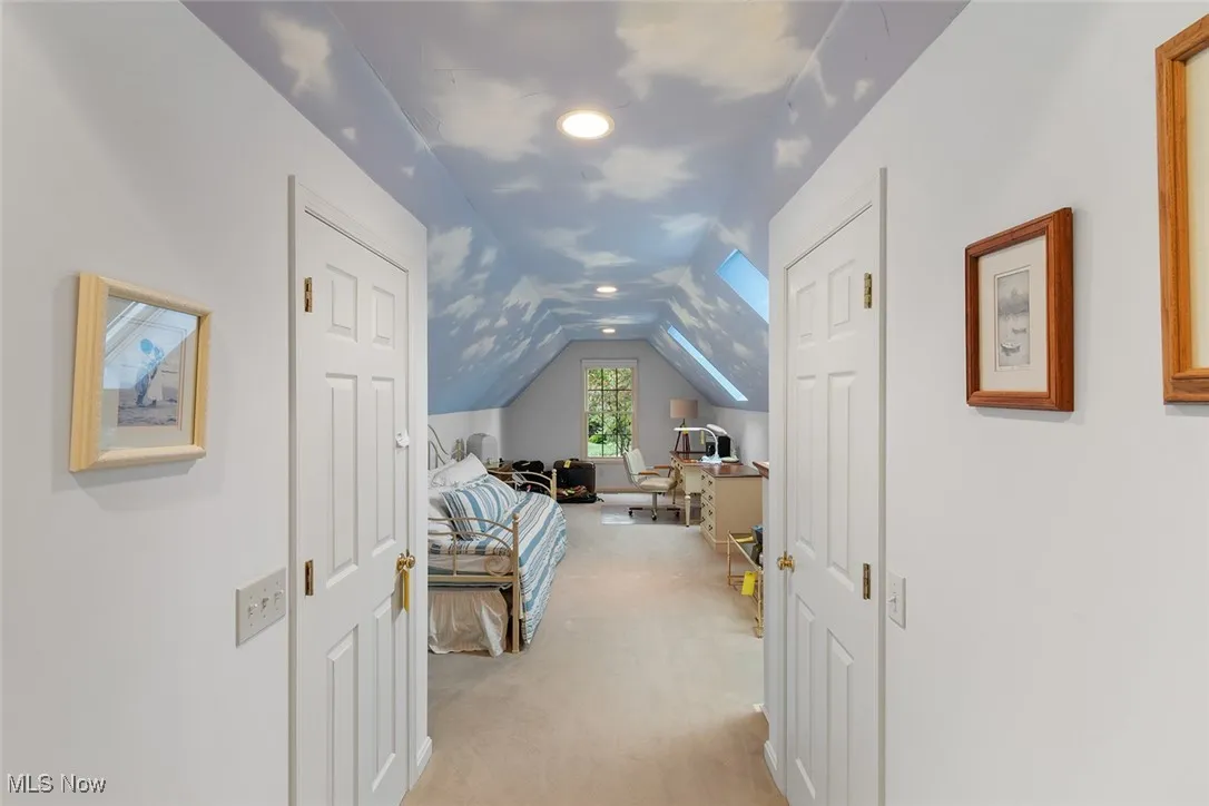Bedroom with light colored carpet, lofted ceiling, and recessed lighting