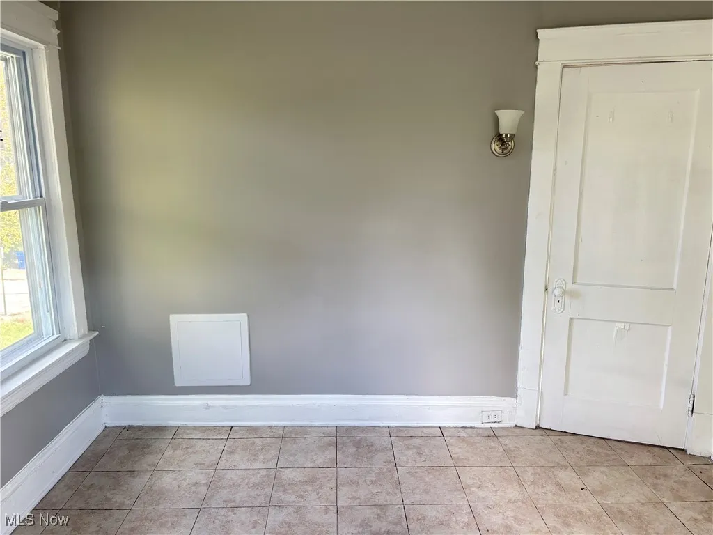 Tiled empty room featuring baseboards