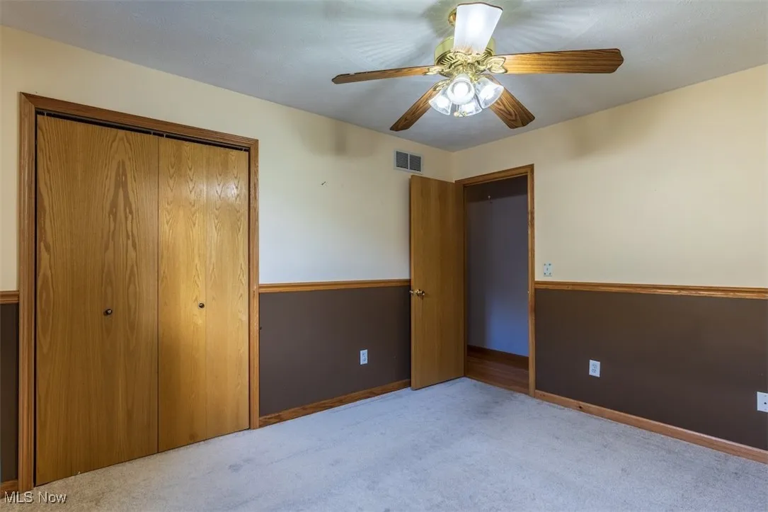 Unfurnished bedroom featuring a closet, carpet floors, and ceiling fan