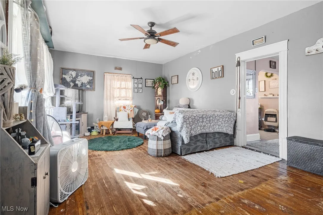 Living room with hardwood / wood-style floors and a ceiling fan