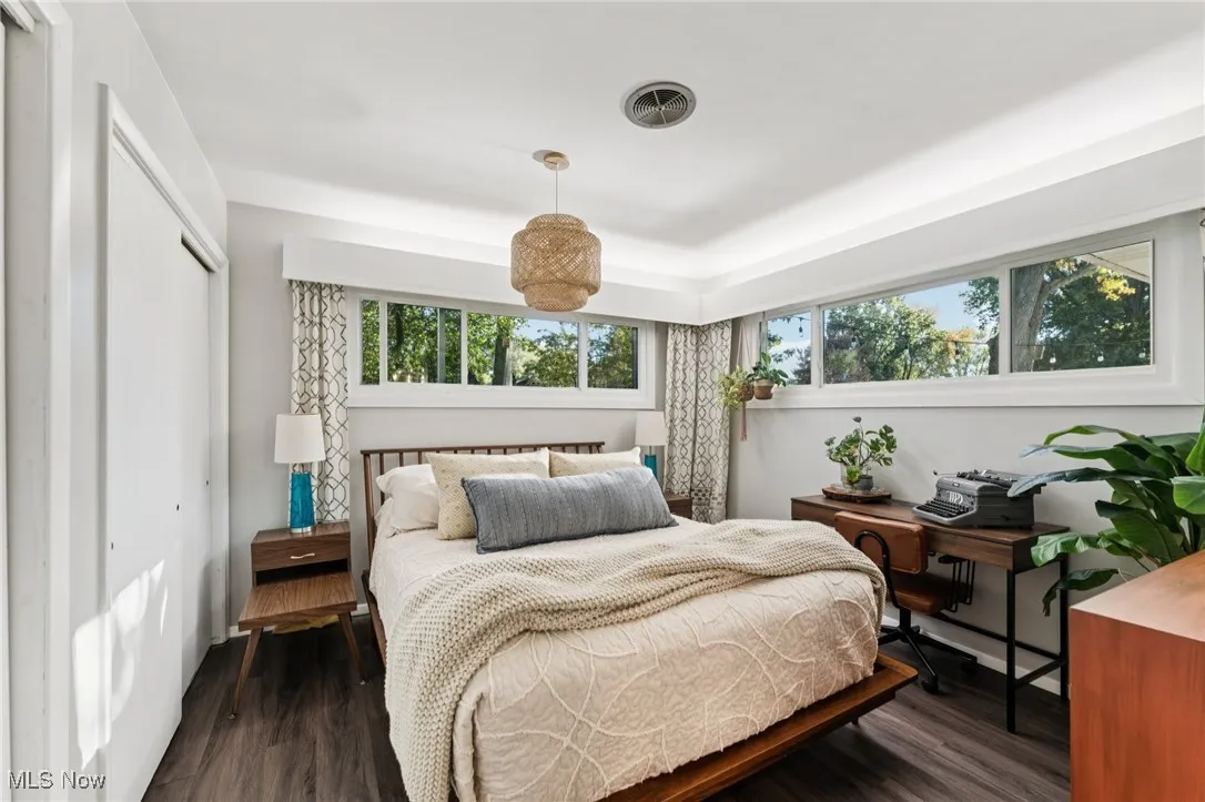 Bedroom with a closet and dark wood-type flooring